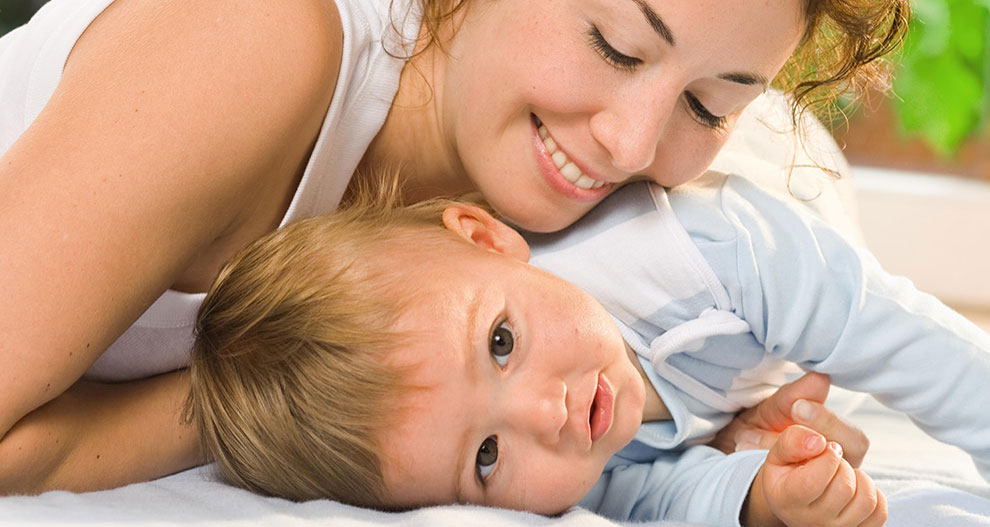 A woman lovingly embraces a baby.