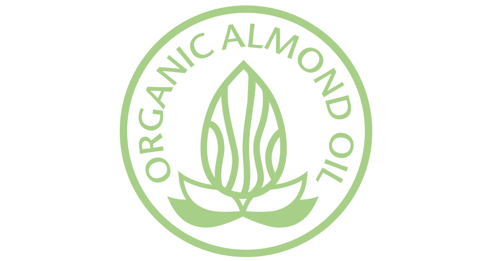 Ett cirkulärt grönt emblem med orden "ORGANIC ALMOND OIL" inskrivna runt omkretsen, med en stiliserad mandelnöt i mitten.